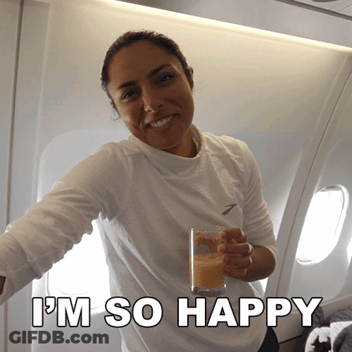 A Woman Holding A Glass Of Orange Juice With The Words I 'M So Happy On The Bottom GIF