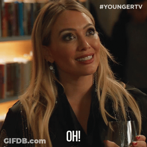 A Woman Holding A Glass Of Wine And Saying Oh GIF