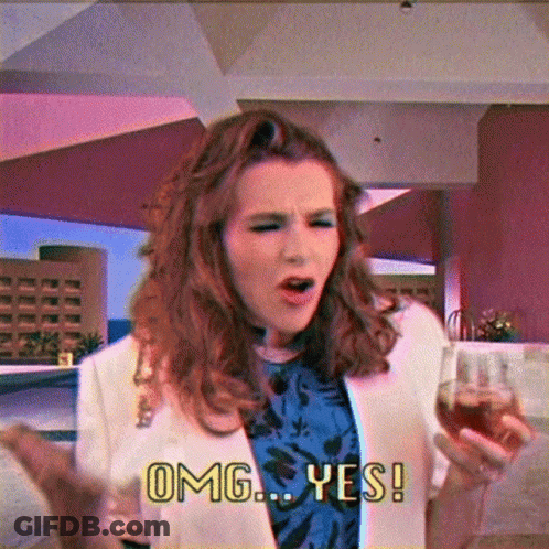 A Woman Holding A Glass Of Wine And Saying Omg Yes GIF