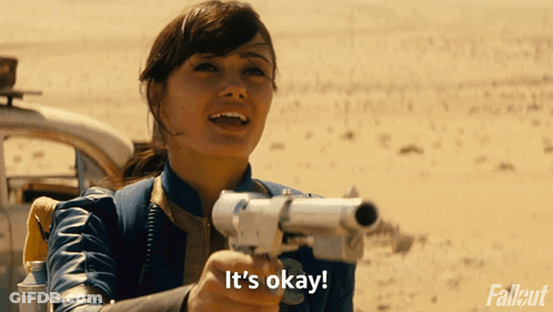 A Woman Holding A Gun With The Words It 'S Okay On The Bottom GIF