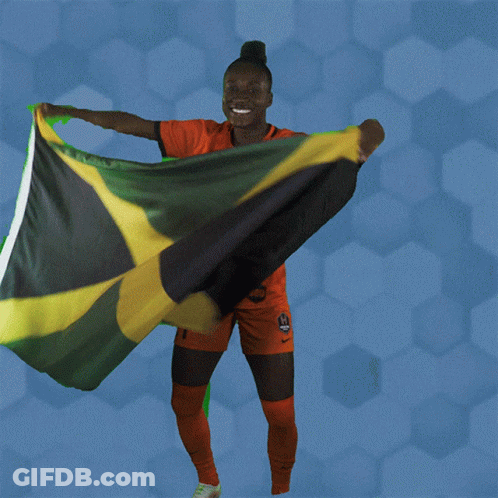 A Woman Holding A Jamaican Flag In Her Hands GIF