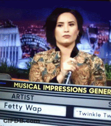 A Woman Holding A Microphone Behind A Sign That Says Musical Impressions Gener GIF