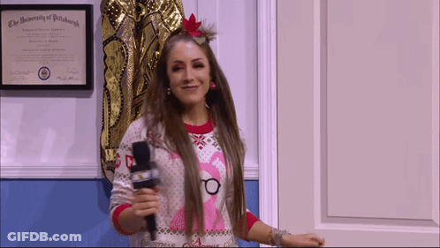 A Woman Holding A Microphone In Front Of A University Of Pittsburgh Certificate GIF