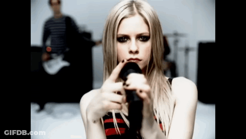A Woman Holding A Microphone In Front Of Her Face GIF