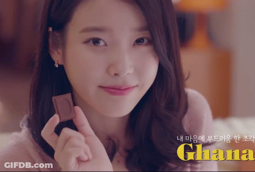 A Woman Holding A Piece Of Chocolate With The Word Ghana In Yellow GIF