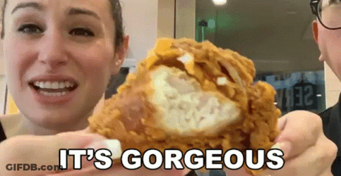 A Woman Holding A Piece Of Fried Chicken With The Words It 'S Gorgeous GIF