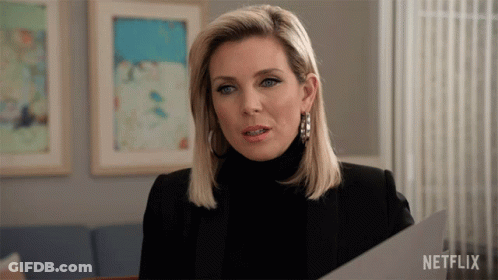 A Woman Holding A Piece Of Paper With Netflix Written On The Bottom Right GIF