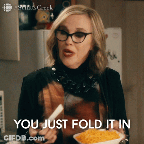 A Woman Holding A Plate Of Food With The Words You Just Fold It In GIF