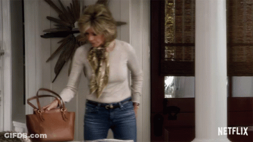 A Woman Holding A Purse In Front Of A Netflix Sign GIF