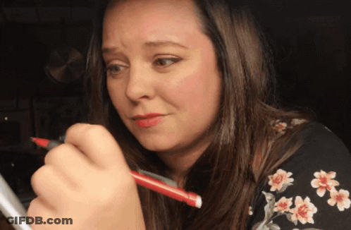 A Woman Holding A Red Pen In Her Right Hand GIF