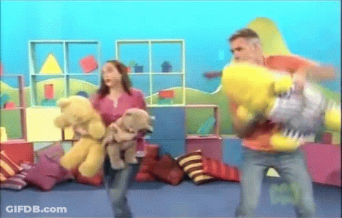 A Woman Holding A Teddy Bear And A Man Holding A Yellow Stuffed Animal GIF