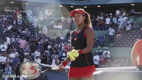 A Woman Holding A Tennis Racquet And A Tennis Ball GIF