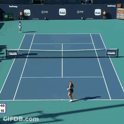 A Woman Holding A Tennis Racquet In Front Of A Lex Clock GIF
