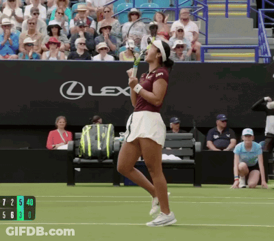 A Woman Holding A Tennis Racquet In Front Of A Lexus Banner GIF