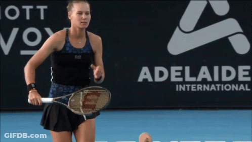 A Woman Holding A Tennis Racquet In Front Of An Adelaide International Sign GIF