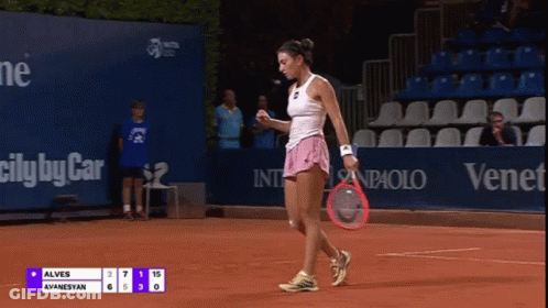 A Woman Holding A Tennis Racquet On A Court With A Scoreboard That Says Alves Ayanesyan GIF
