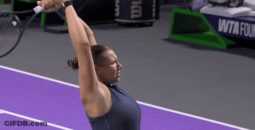 A Woman Holding A Tennis Racquet On A Purple Court GIF
