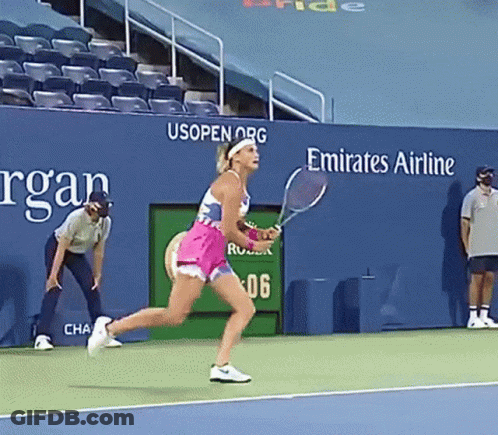 A Woman Holding A Tennis Racquet On A Tennis Court In Front Of A Emirates Airline Sign GIF