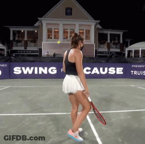 A Woman Holding A Tennis Racquet On A Tennis Court In Front Of A Swing For Cause Banner GIF