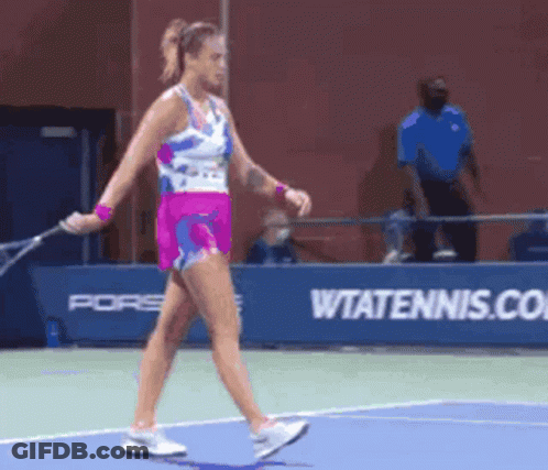 A Woman Holding A Tennis Racquet On A Tennis Court In Front Of A Wtatennis.com Sign GIF