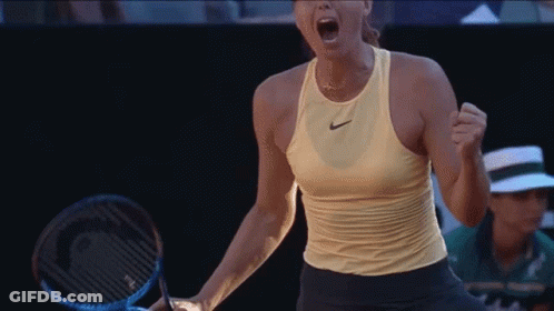 A Woman Holding A Tennis Racquet With Her Mouth Open GIF