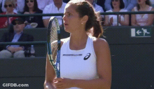 A Woman Holding A Tennis Racquet With The Word Porsche On Her Tank Top GIF