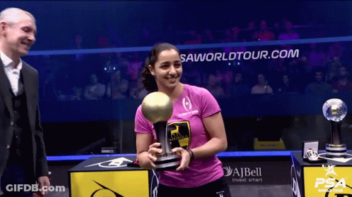 A Woman Holding A Trophy In Front Of A Sign That Says ' Saworldtour.com ' GIF