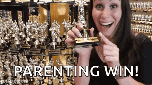 A Woman Holding A Trophy With The Words Parenting Win Written On The Bottom GIF