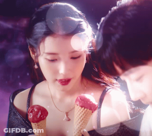 A Woman Holding Two Ice Cream Cones In Her Hand GIF