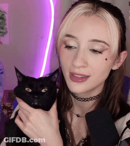 A Woman Holds A Black Cat In Her Arms GIF