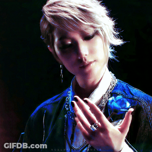 A Woman Holds A Blue Rose In Her Hand With A Ring On Her Left Hand GIF