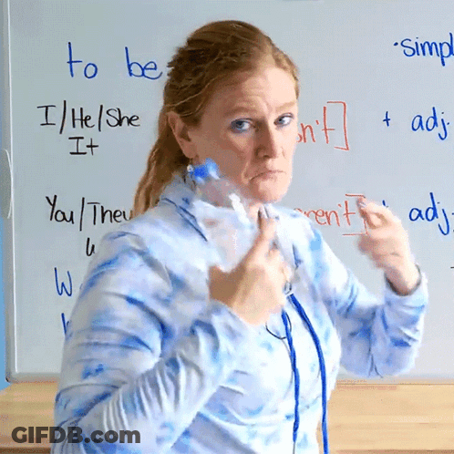 A Woman Holds A Bottle In Front Of A Whiteboard That Says To Be GIF