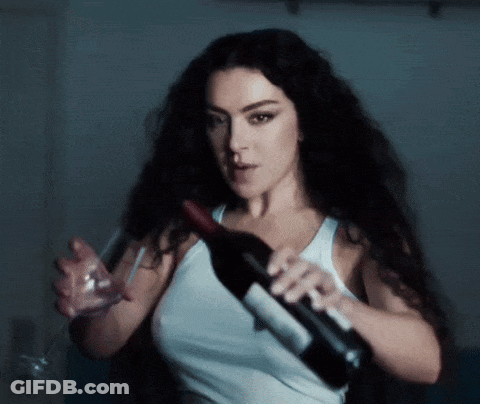 A Woman Holds A Bottle Of Wine And A Glass GIF