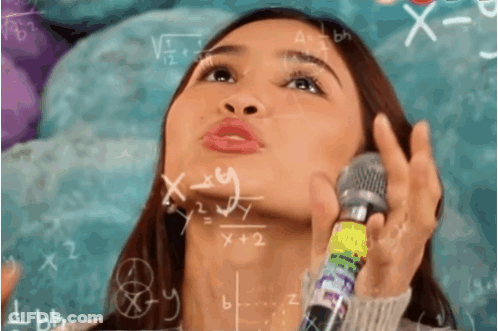 A Woman Holds A Microphone In Front Of A Chalkboard With Math Equations GIF