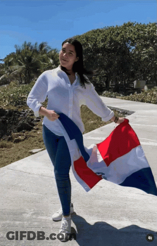 A Woman Holds A Red White And Blue Flag In Her Hand GIF