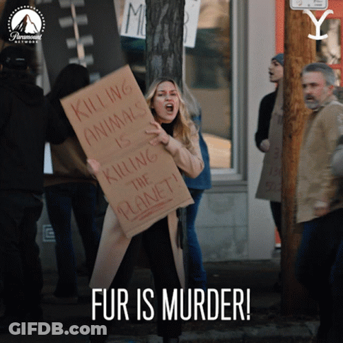 A Woman Holds A Sign That Says Killing Animals Is Killing The Planet GIF