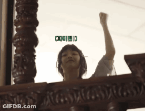 A Woman Holds Her Fist Up In The Air With A Green Sticker That Says ' I ' On It GIF