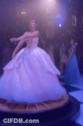 A Woman In A Ball Gown Is Dancing On A Clock GIF