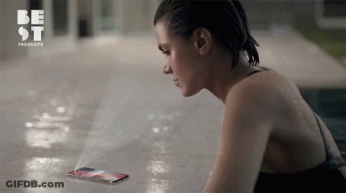 A Woman In A Bathing Suit Is Looking At A Phone That Says Best Products On The Bottom GIF