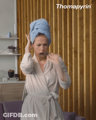 A Woman In A Bathrobe With A Towel Wrapped Around Her Head And The Word Thomapyrin Behind Her GIF