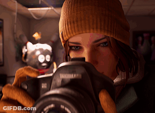 A Woman In A Beanie Is Taking A Picture With A Camera That Says ' Vanderbilt ' On It GIF