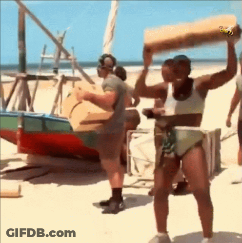 A Woman In A Bikini Is Carrying A Large Piece Of Wood GIF