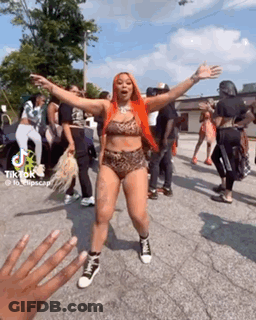A Woman In A Bikini Is Dancing In Front Of A Crowd . GIF
