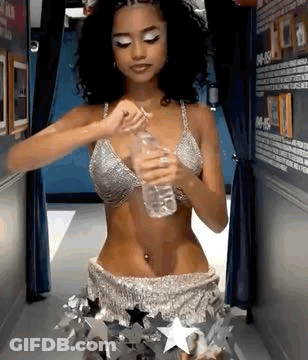 A Woman In A Bikini Is Holding A Bottle Of Water In Her Hand . GIF