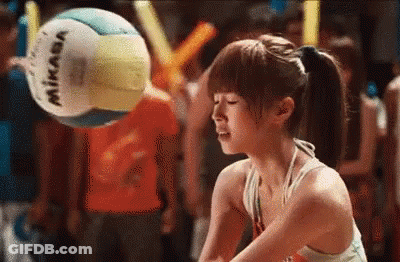 A Woman In A Bikini Is Playing Volleyball With A Mikasa Volleyball In The Background . GIF
