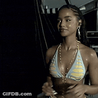 A Woman In A Bikini Is Smiling And Wearing A Necklace GIF