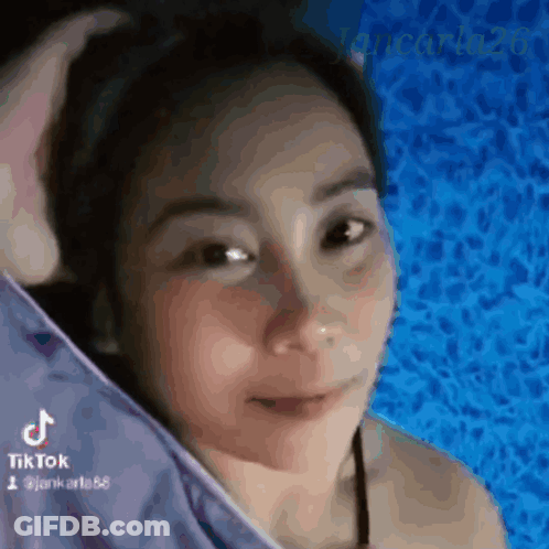 A Woman In A Bikini Is Standing In Front Of A Blue Pool . GIF