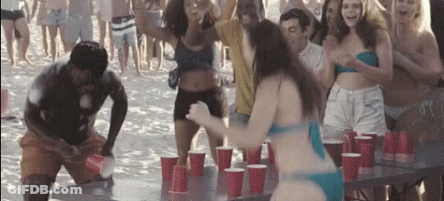 A Woman In A Bikini Is Standing In Front Of A Table With Red Cups On It . GIF