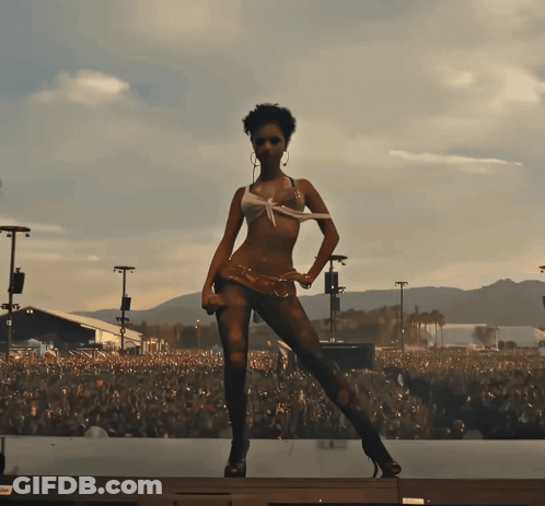 A Woman In A Bikini Stands On A Stage In Front Of A Crowd Of People GIF