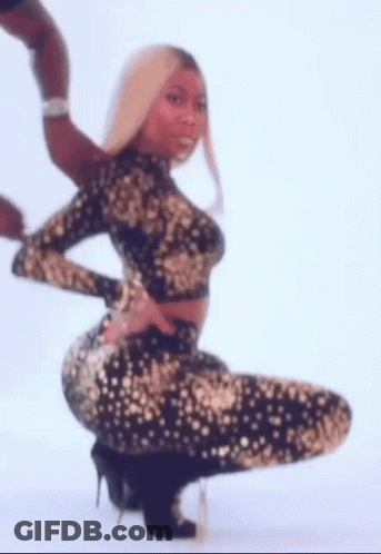 A Woman In A Black And Gold Dress Is Kneeling Down And Holding Her Butt . GIF
